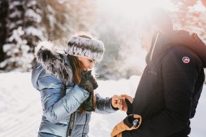 Artistic photo of Fernanda admiring her engagement ring while Julio hold her hand for this sleigh ride proposal in Breckenridge