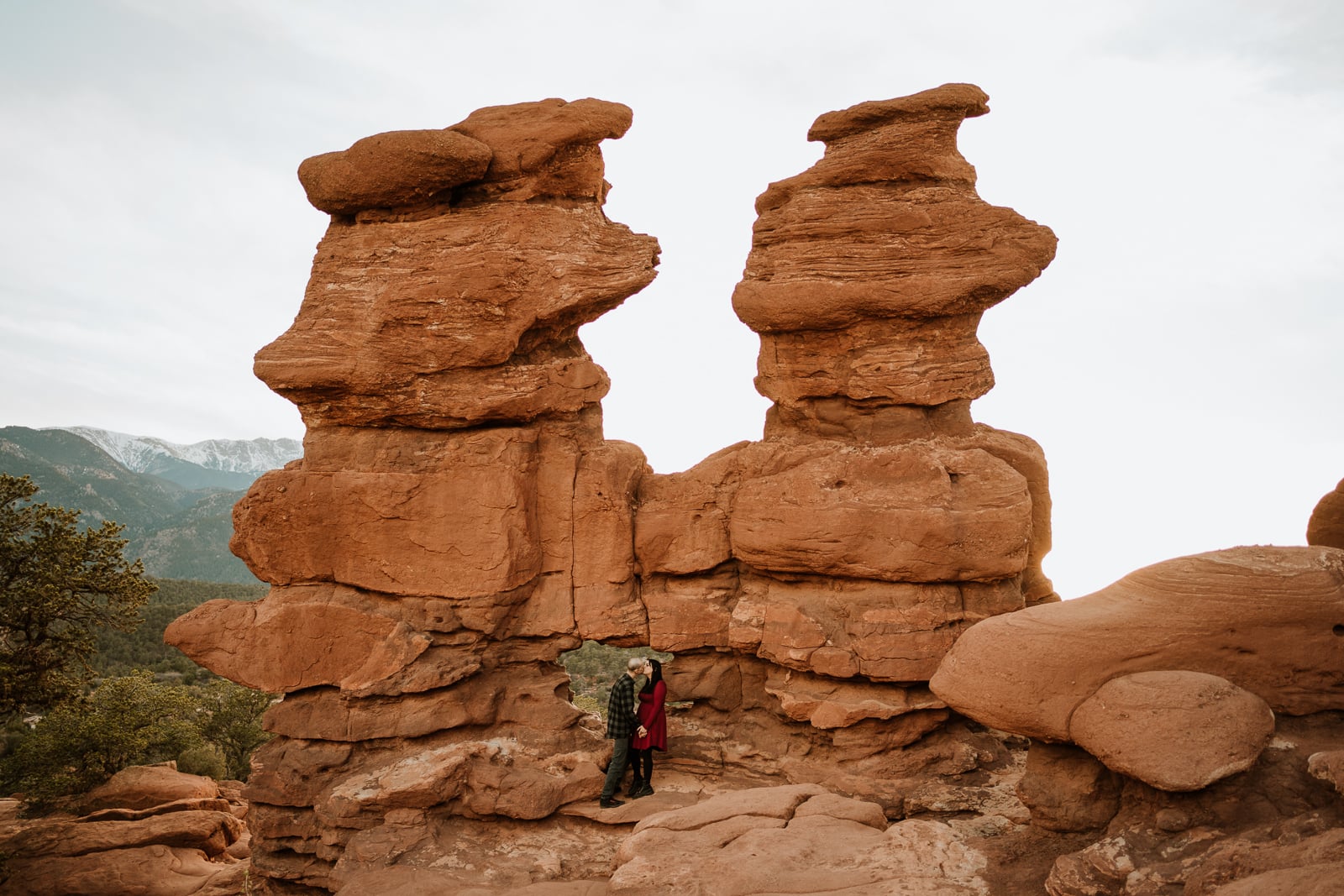 Couple stands at the top Siamese Twins trailhead for their Garden of the Gods engagement photos in spring