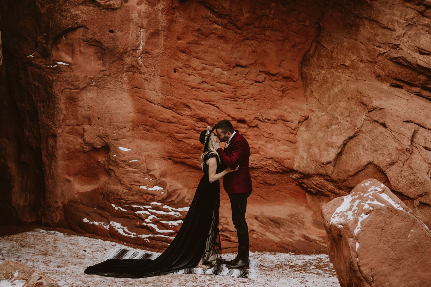 Bride and groom eloped at Sentinel Plaza in Garden of the Gods during the winter, and this is an image of their first kiss next to a dramatic rock formation