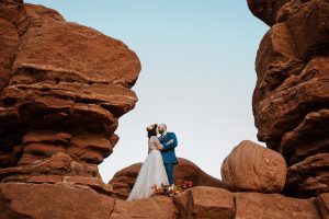 Photo of bride and groom kissing in rock formation at Garden of the Gods
