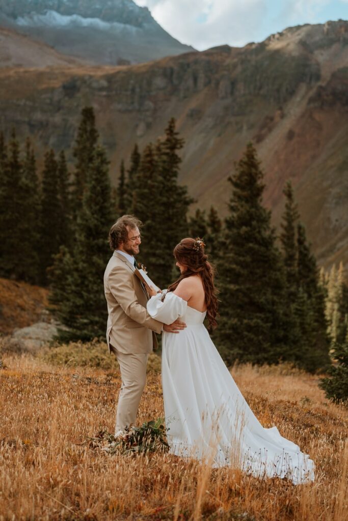 Bride reads her wedding vows to her husband with Mt. Sneffels in the background.