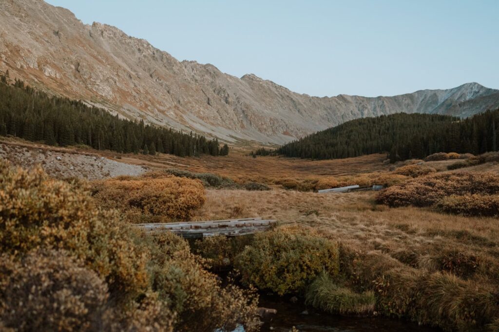 Wide landscape photo that shows the mountains behind Clinton Gulch reservoir at dusk.