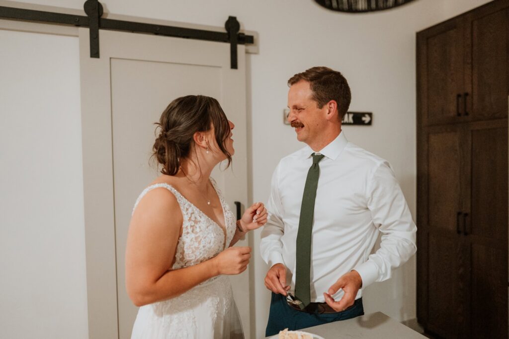 Bride and groom smile at each other just after the celebration cake cutting.