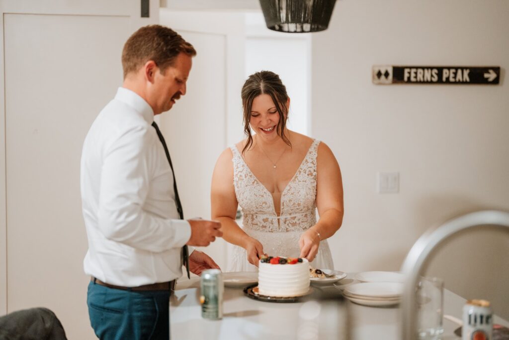 Bride serves cake to her groom for their celebration at an AirBNB after their small mountain wedding in Colorado.