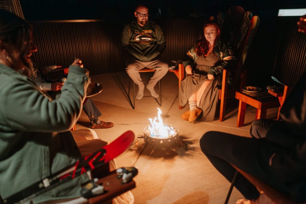 Guests gather around a propane firepit during the celebration portion of a small mountain wedding in Colorado.