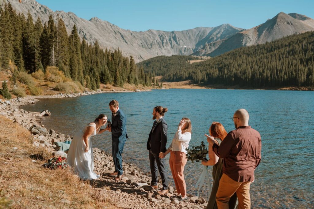 The bride is bending over laughing hard at a joke one of the guests told before the ceremony started.