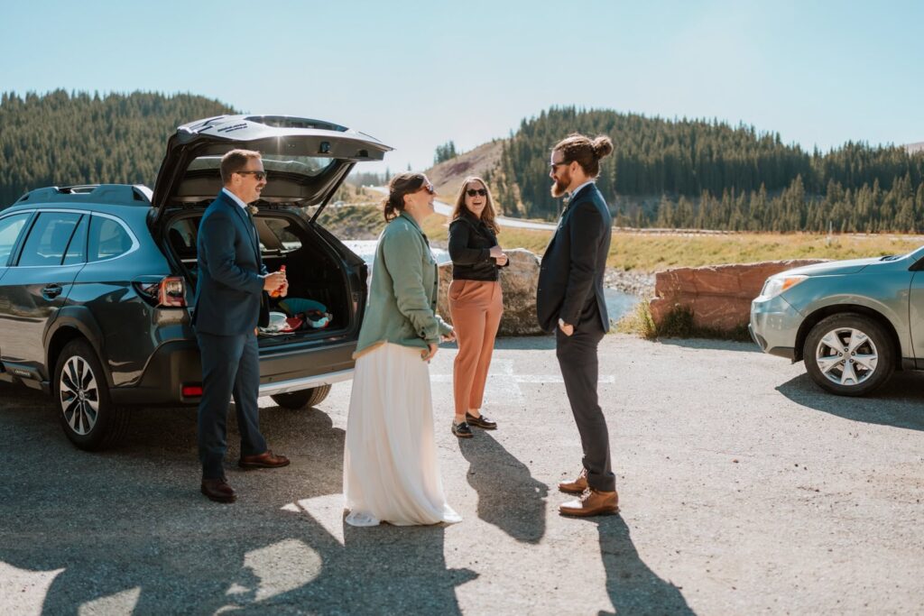 Wedding couple and their guests talk in the parking lot at Clinton Gulch before walking down to their intimate wedding location