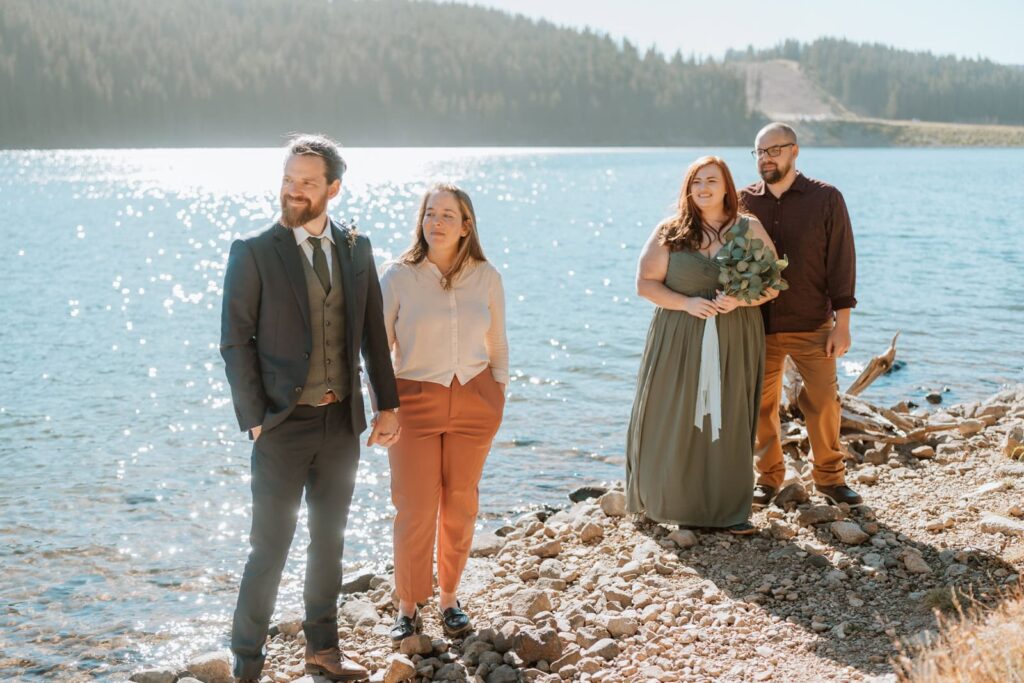 The 4 guests are shown with smiling faces as they watch the bride and groom get married.