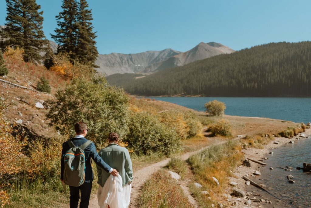 The bride and groom walk down the hiking path at Clinton Gulch reservoir in Breckenridge Colorado.