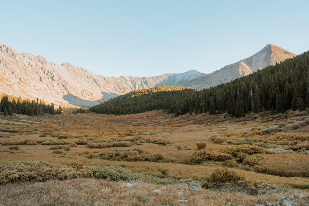 Wide photo shows the alpenglow on the mountains outside of Clinton Gulch.