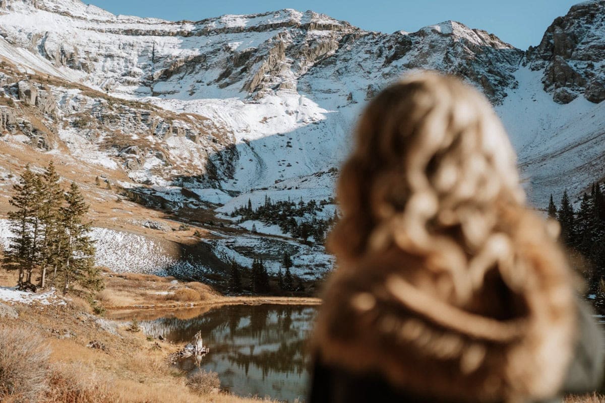 Bride overlooking an alpine lake during a fall Telluride elopement in the San Juan Mountains