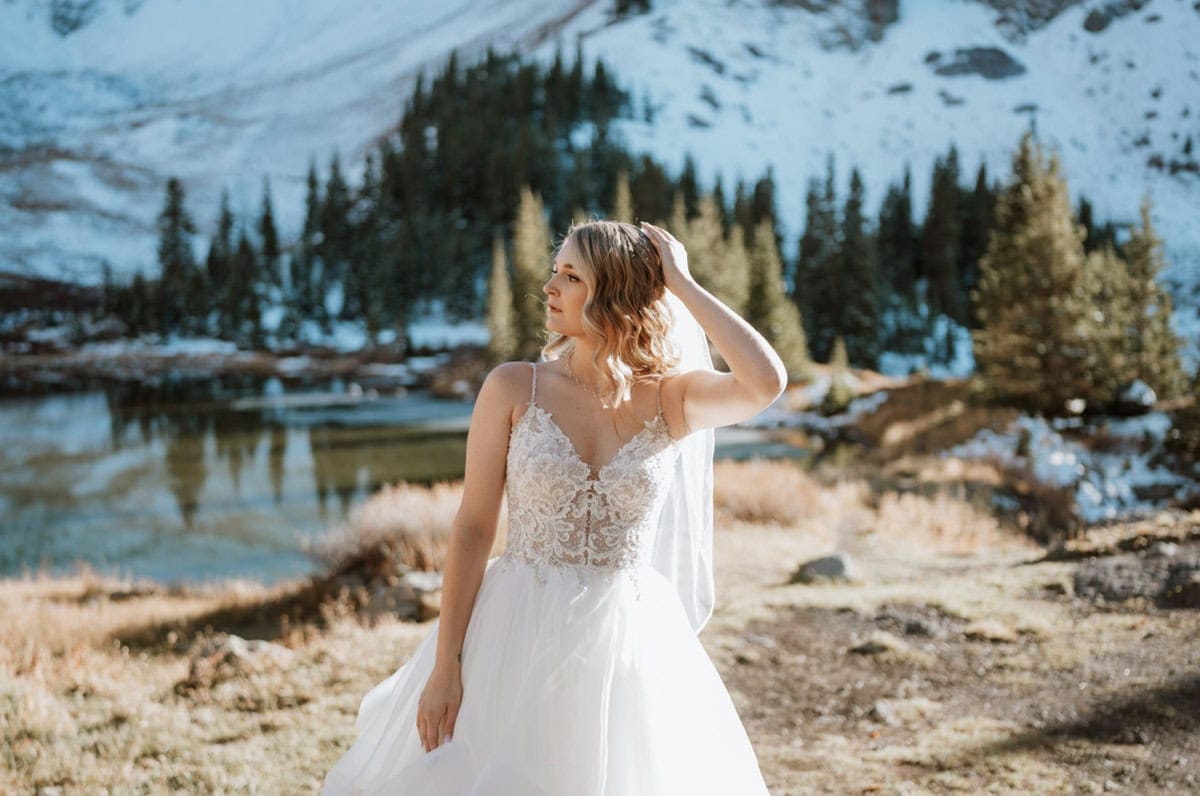 Bride pausing before her Telluride elopement ceremony, surrounded by snow-dusted pines