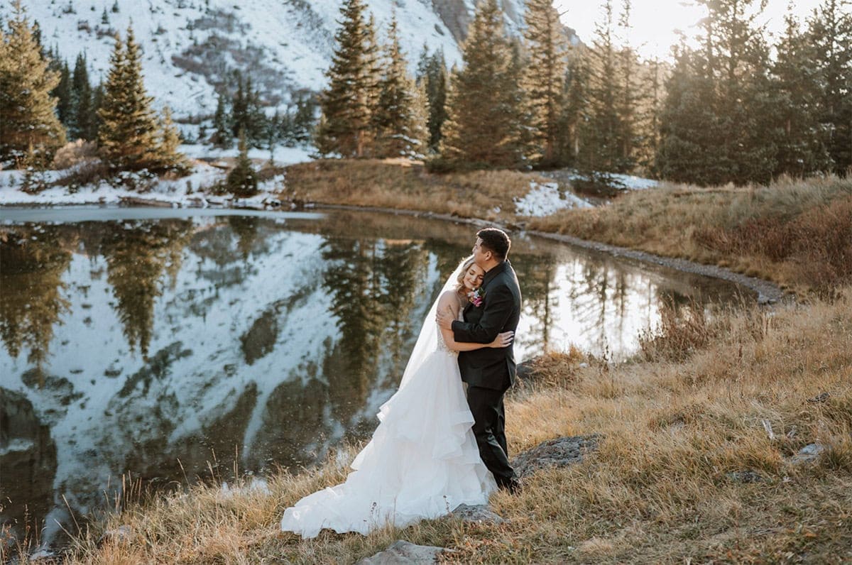 Candid embrace during a Telluride elopement near a reflective alpine lake in Colorado