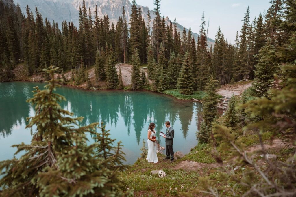 Bride and groom read their elopement ceremony script next to a bright blue alpine lake for their elopement in Ouray. Photographed by Colorado elopement photographer, Paige Weber photography
