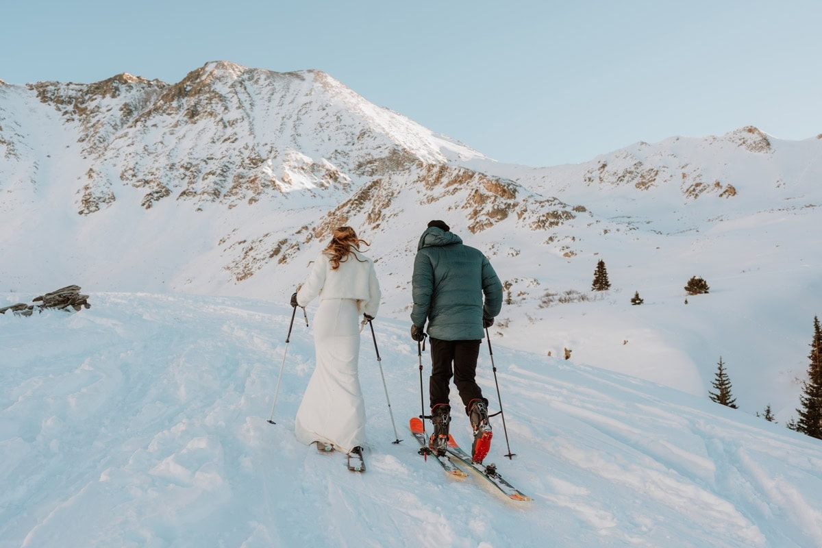 Couple ski touring together during a backcountry skiing elopement at Mayflower Gulch in Colorado