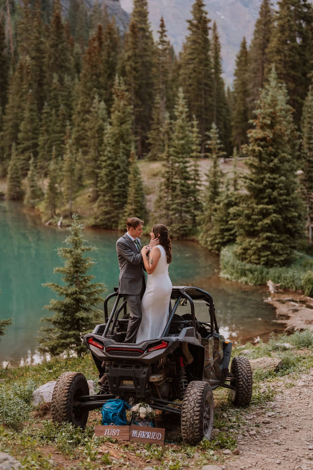 Couple standing together on a side by side vehicle during a wedding in the alpine landscape of Ouray.