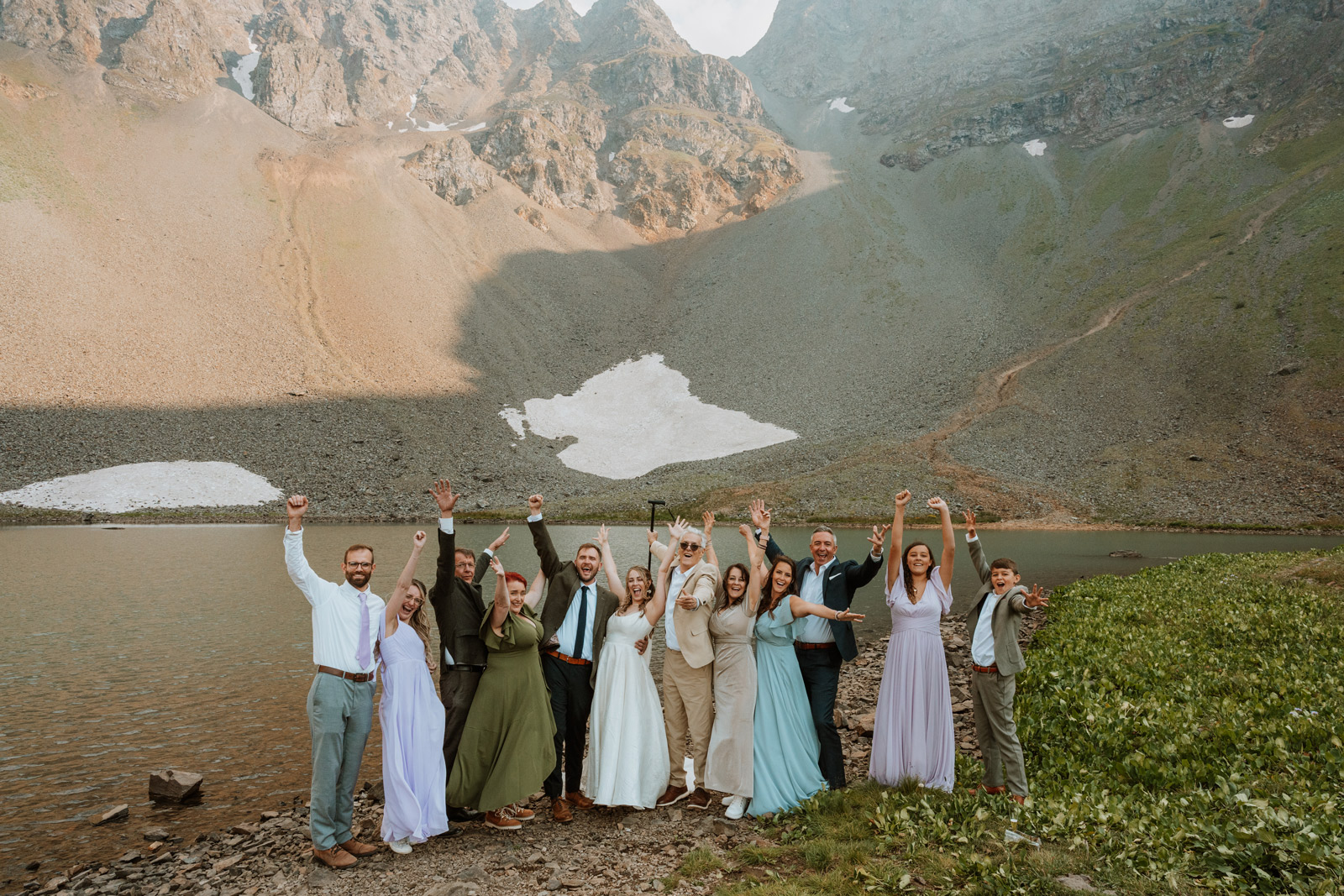 Elopement couple celebrates with 11 guests at a micro wedding ceremony beside a high-elevation alpine lake in the San Juan Mountains.